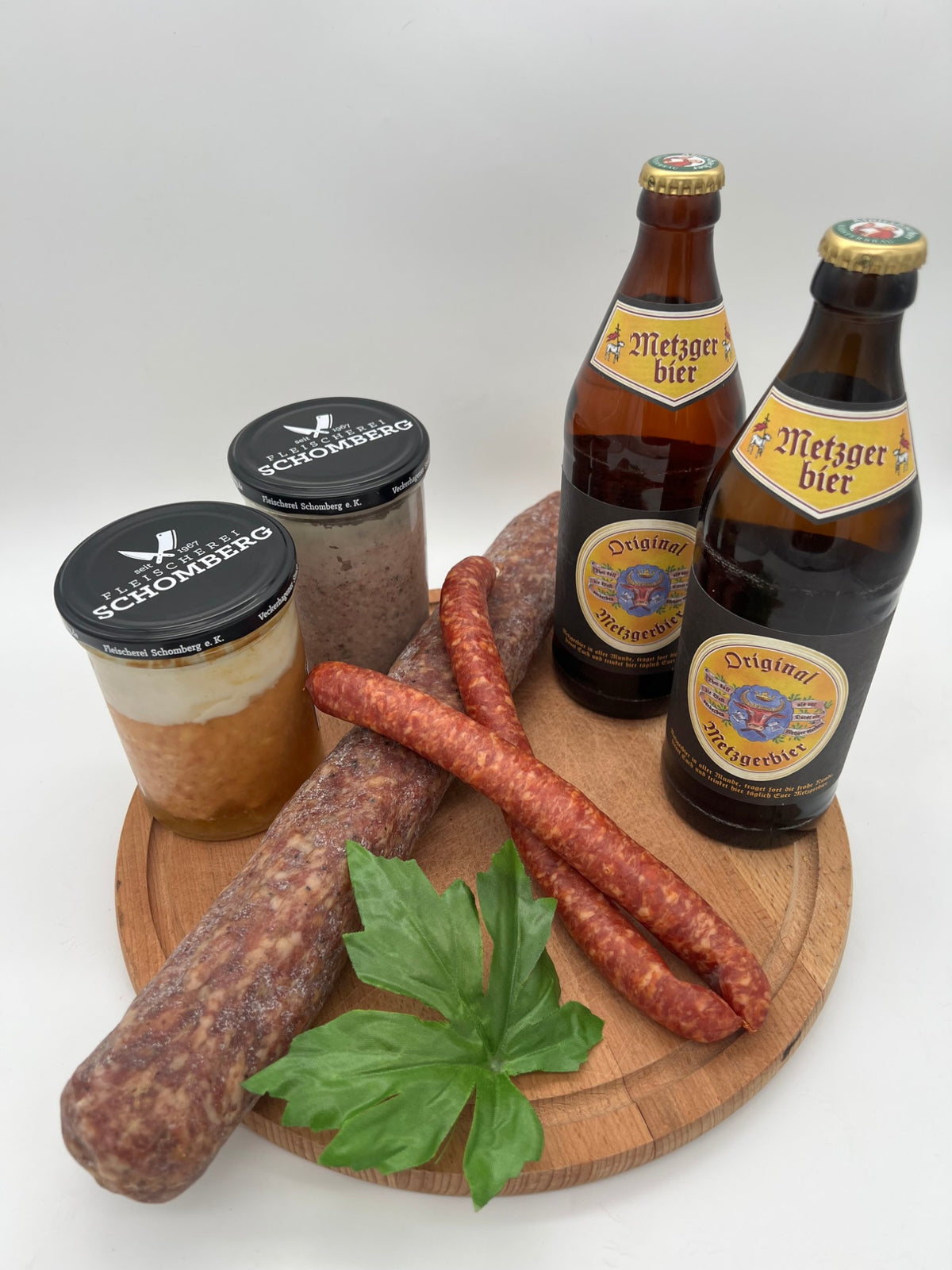 Männerabend-Auswahl der Fleischerei Schomberg mit Ahler Wurscht, Würstchen und Gläsern (Beispielfoto, zeigt eine Auswahl, Bier und Blatt = Deko)