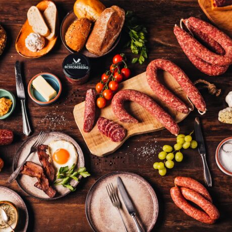 Ahle Wurst Rund Angerichtet mit Weintrauben, Speck und Ei auf einem Rustikalem Holzbrett