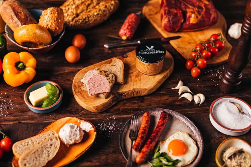 Gehacktes im Glas auf einem Holzbrett und Leckeres gehacktes verstrichen auf einem stück Brot