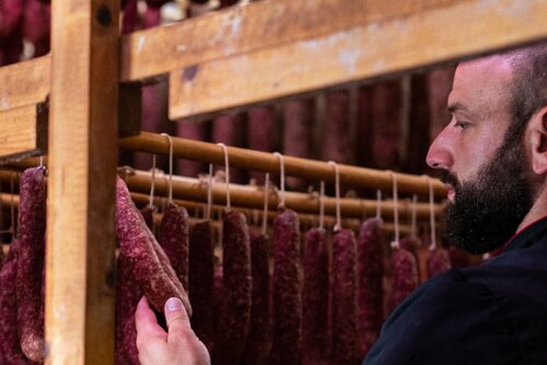 Patrick Friedrich, Inhaber der Fleischerei Schomberg, kontrolliert in der Reifekammer die traditionelle Ahle Wurscht